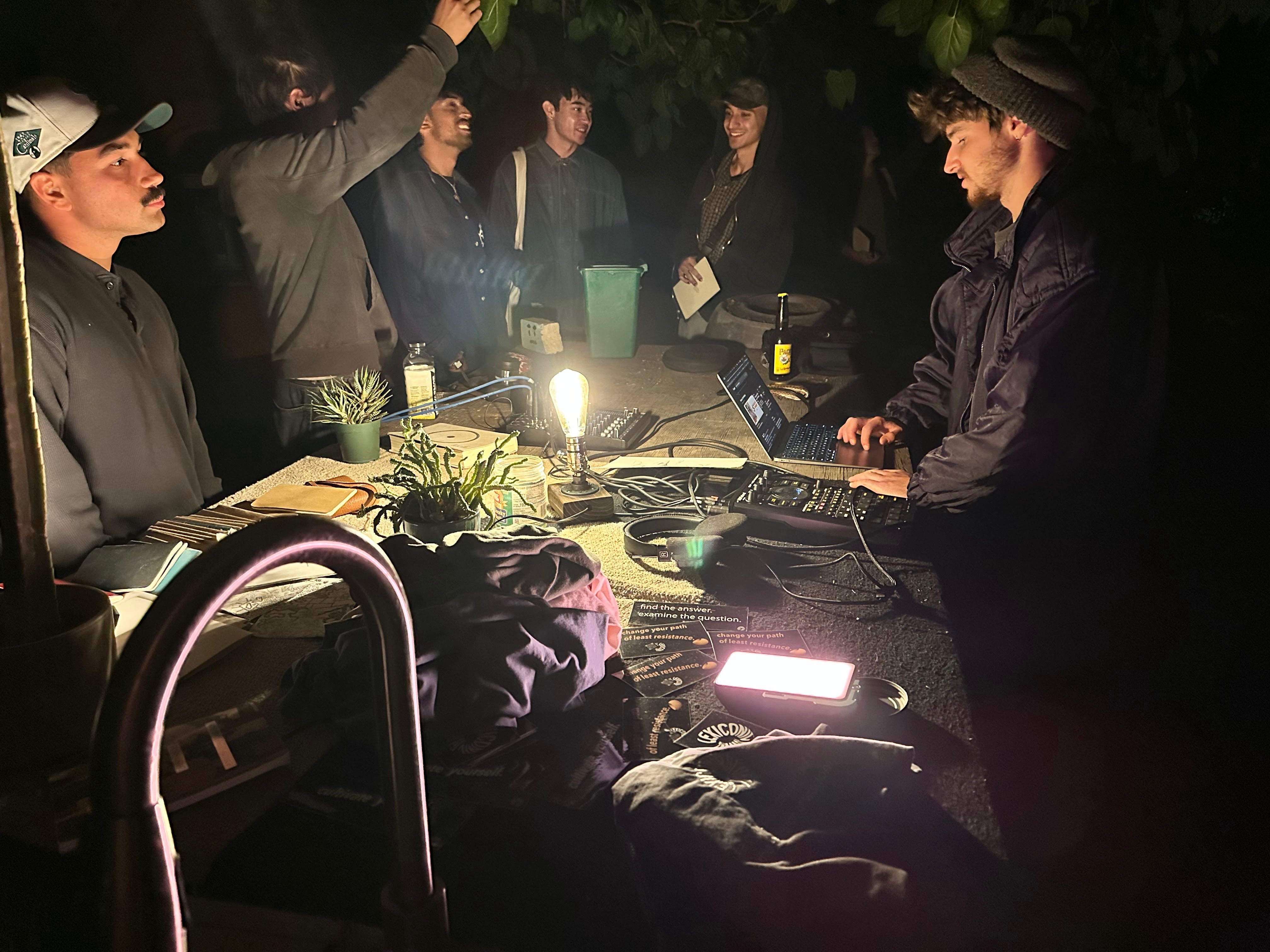 The artist at a sound collage setup with attendees gathered around